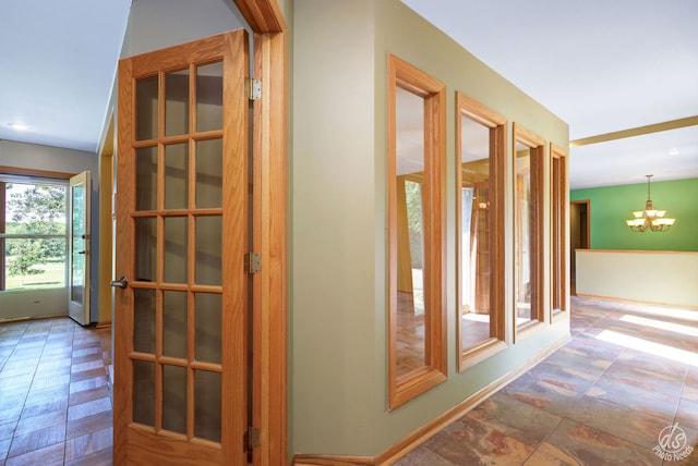 unfurnished living room with french doors, light parquet flooring, and a notable chandelier