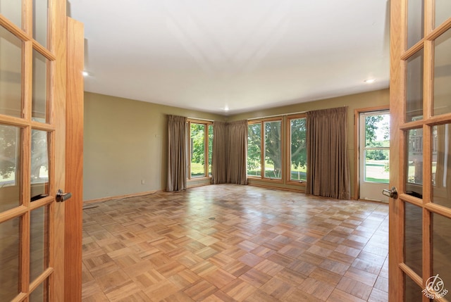 unfurnished room featuring french doors and light parquet floors