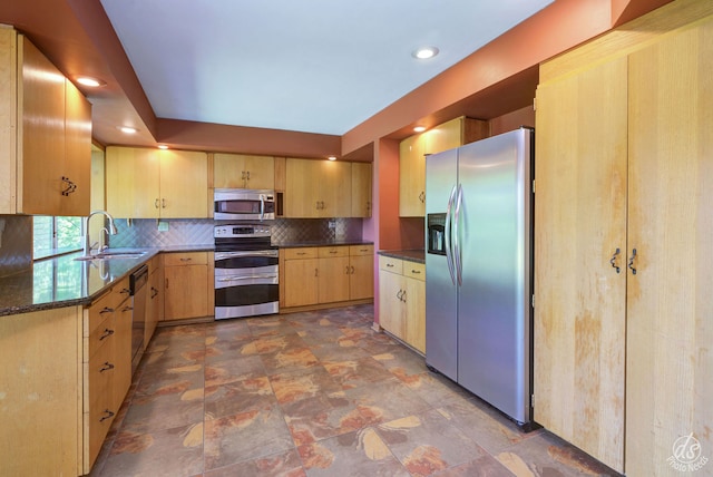 kitchen featuring backsplash, sink, light brown cabinetry, appliances with stainless steel finishes, and decorative light fixtures