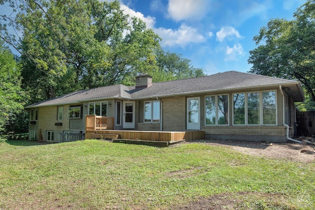 rear view of property featuring a deck and a yard