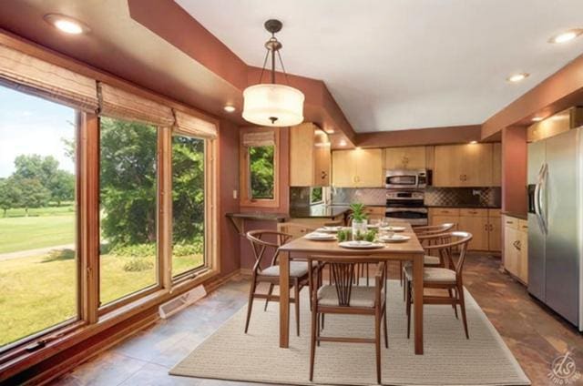 kitchen with decorative backsplash, dark stone counters, stainless steel appliances, sink, and light brown cabinets