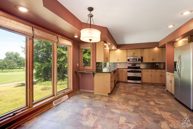 kitchen with sink, decorative backsplash, light brown cabinetry, appliances with stainless steel finishes, and decorative light fixtures