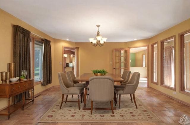 dining space with a notable chandelier and parquet flooring