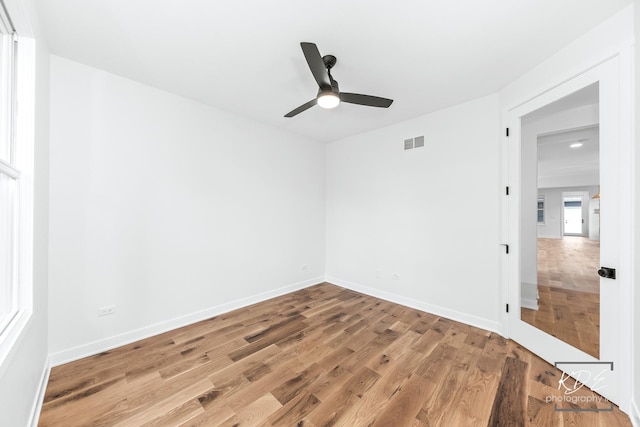 spare room with visible vents, light wood-style floors, ceiling fan, and baseboards