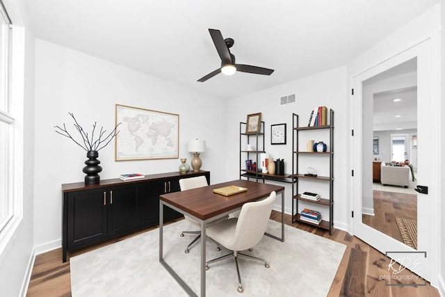 office area featuring baseboards, ceiling fan, wood finished floors, and visible vents