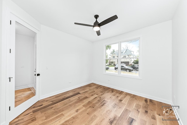 empty room featuring baseboards, ceiling fan, and light wood-style flooring