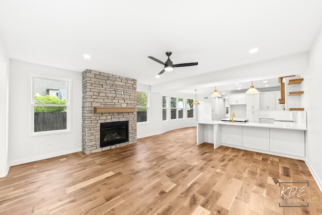 unfurnished living room with light wood-style floors, baseboards, and ceiling fan