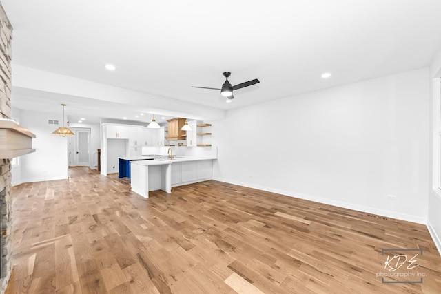 unfurnished living room with recessed lighting, light wood-style flooring, ceiling fan, and baseboards