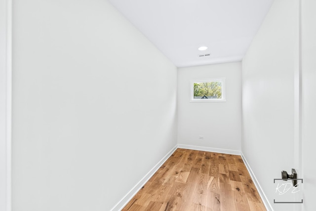 empty room featuring baseboards, visible vents, and light wood-style floors