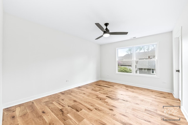 spare room featuring baseboards, a ceiling fan, light wood finished floors, and visible vents