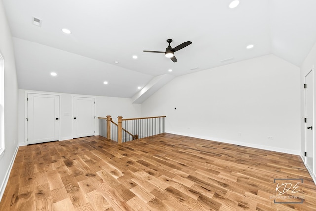 additional living space featuring visible vents, light wood-style floors, ceiling fan, and lofted ceiling
