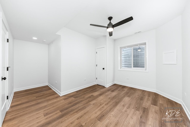 unfurnished bedroom featuring a ceiling fan, visible vents, wood finished floors, baseboards, and recessed lighting