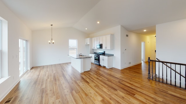 kitchen featuring white cabinetry, an inviting chandelier, appliances with stainless steel finishes, light hardwood / wood-style flooring, and lofted ceiling