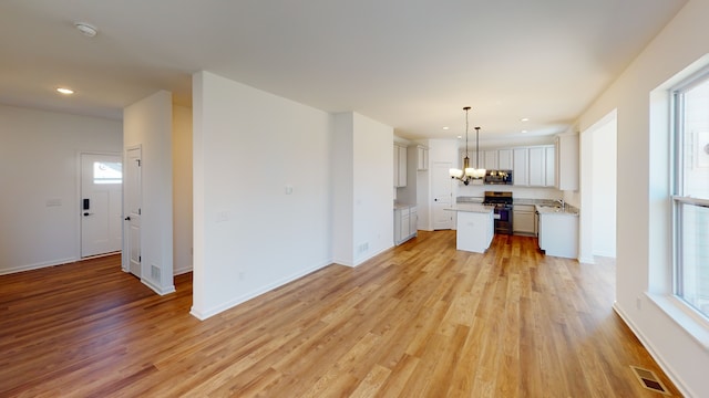 unfurnished living room with plenty of natural light and light hardwood / wood-style flooring