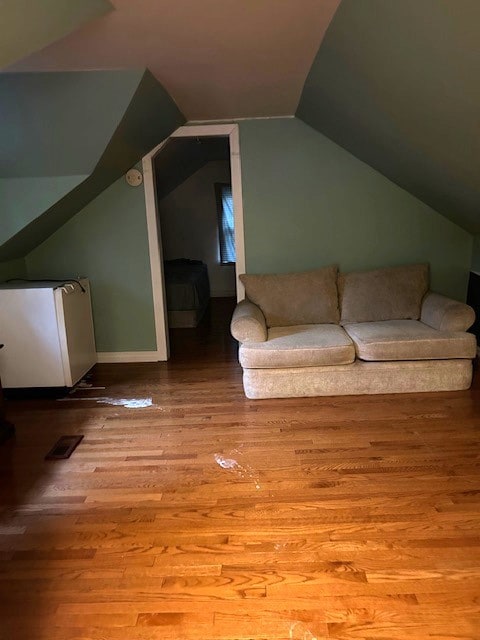 additional living space with light wood-type flooring and vaulted ceiling