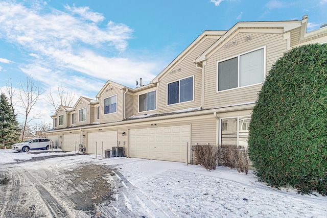 view of front of home with a garage and central air condition unit