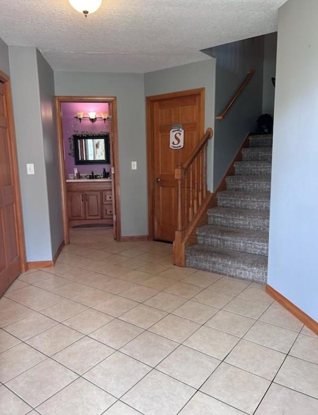 entrance foyer with a textured ceiling and light tile patterned floors