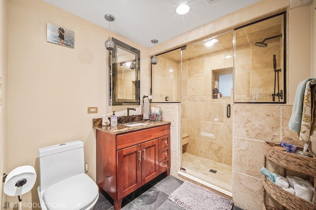 bathroom featuring toilet, a shower stall, and vanity