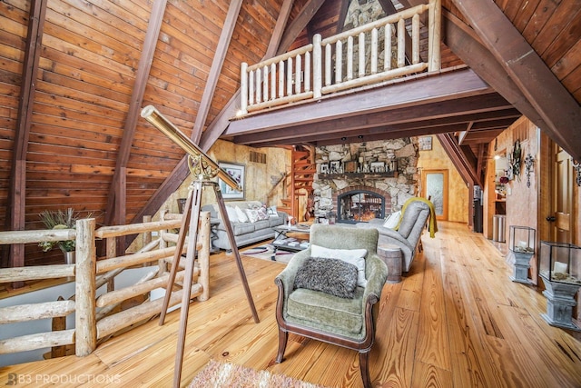 unfurnished living room featuring wooden ceiling, wood finished floors, a stone fireplace, high vaulted ceiling, and beam ceiling