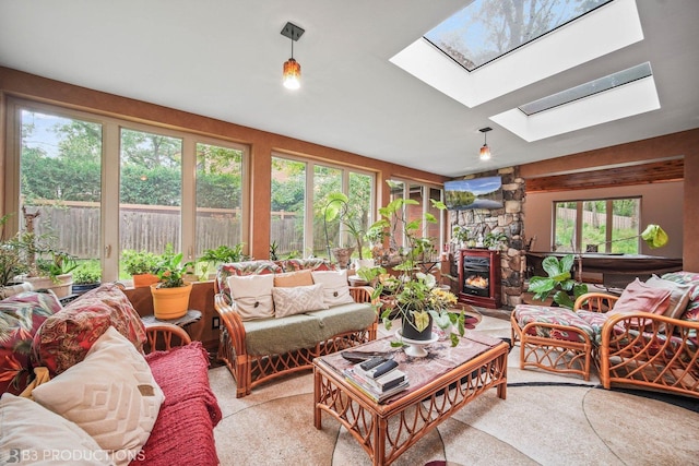 living area with a stone fireplace and a skylight