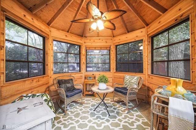 sunroom featuring lofted ceiling with beams, ceiling fan, and wooden ceiling