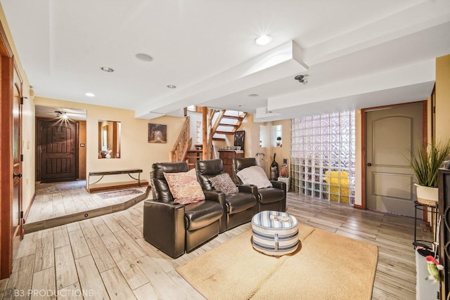 living room with light wood-type flooring, recessed lighting, and stairs