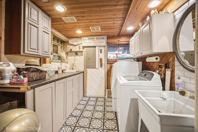 laundry room featuring wood ceiling, light tile patterned flooring, electric panel, and cabinets