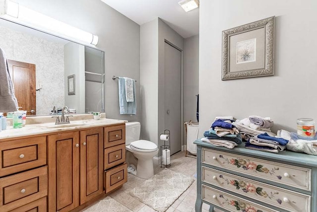 bathroom featuring vanity, toilet, and tile patterned flooring