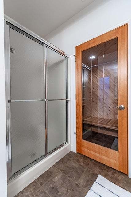 bathroom featuring tile patterned flooring and an enclosed shower