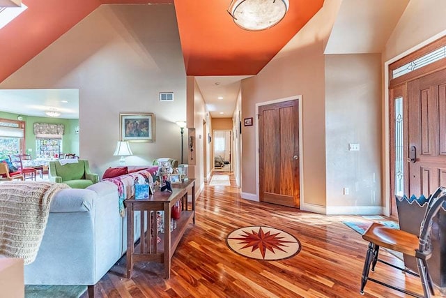 living room featuring high vaulted ceiling and hardwood / wood-style floors