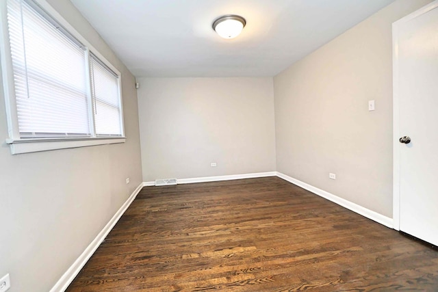 unfurnished room with dark hardwood / wood-style flooring