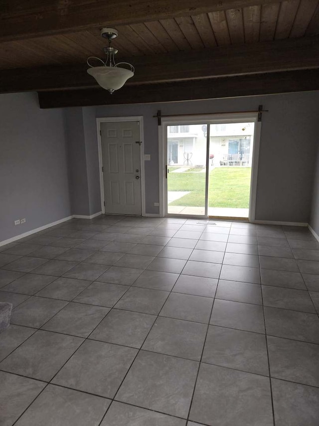 spare room featuring wooden ceiling, light tile patterned flooring, and beam ceiling