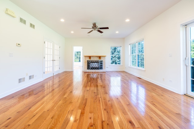 unfurnished living room with plenty of natural light, ceiling fan, and light wood-type flooring