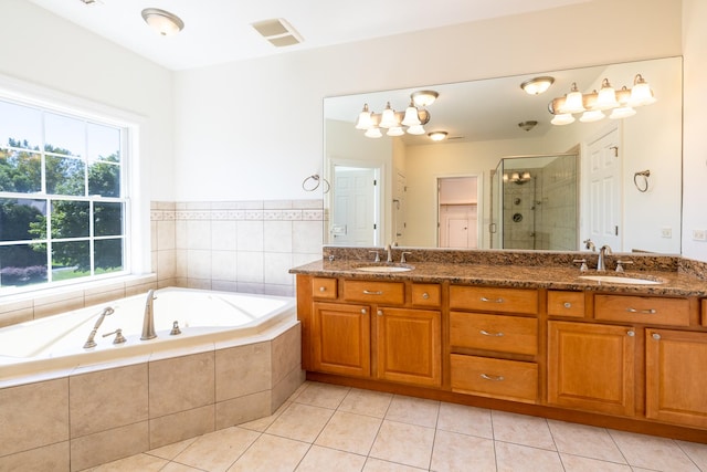 full bath with a shower stall, a sink, a bath, and tile patterned floors