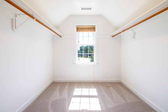 walk in closet with vaulted ceiling, carpet flooring, and visible vents