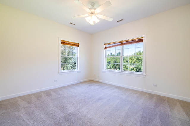 carpeted spare room featuring ceiling fan