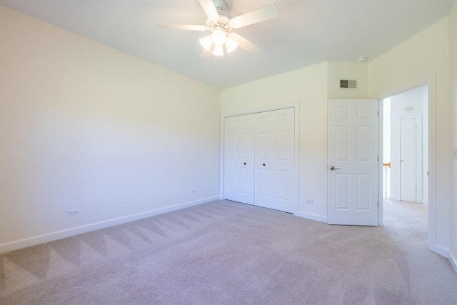 unfurnished bedroom featuring light carpet, a ceiling fan, visible vents, baseboards, and a closet