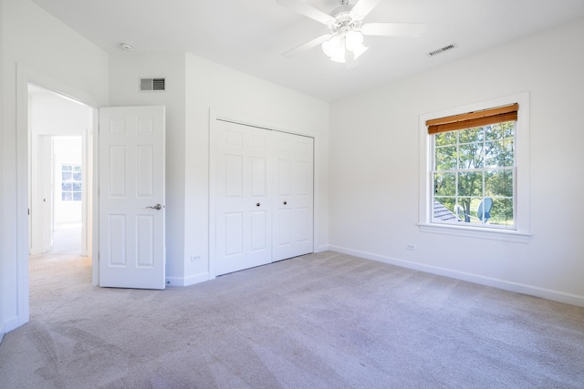 unfurnished bedroom with carpet, a closet, visible vents, and baseboards