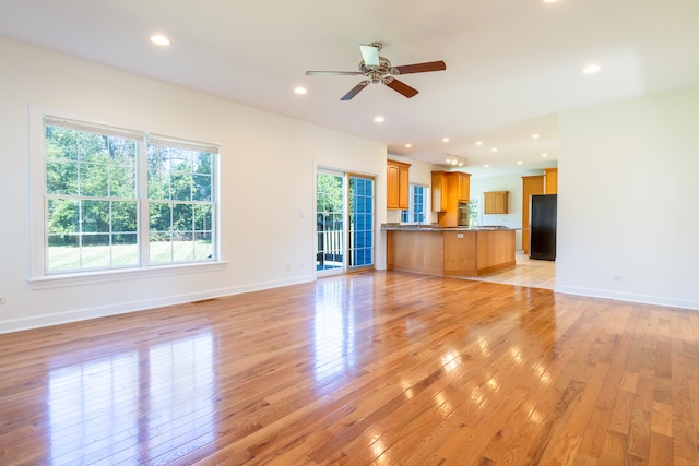 unfurnished living room featuring ceiling fan and light hardwood / wood-style floors