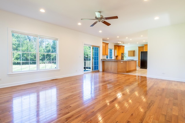 unfurnished living room with light wood-style flooring, baseboards, and recessed lighting