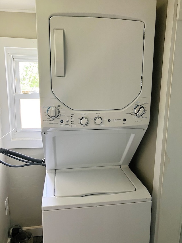 laundry room with stacked washer / dryer