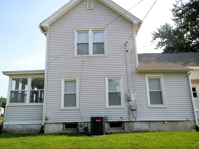 rear view of property with a yard and central AC unit