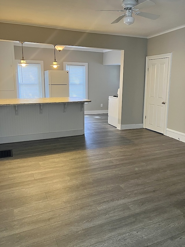 unfurnished living room with washer / clothes dryer, ceiling fan, wood-type flooring, and ornamental molding