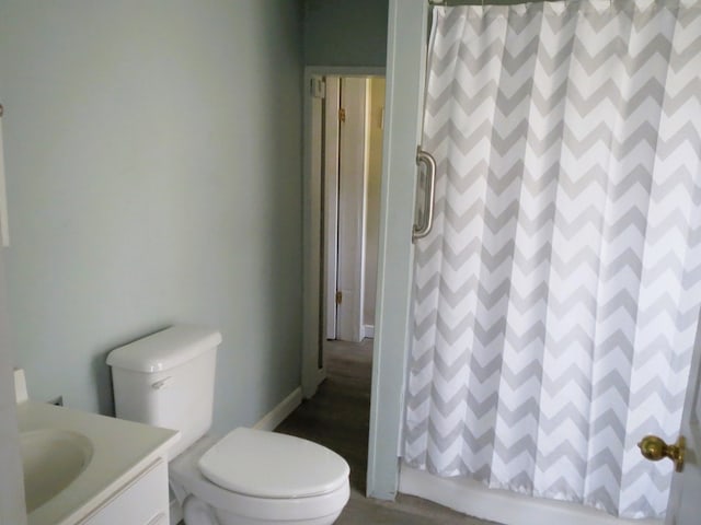 bathroom with a shower with door, vanity, hardwood / wood-style flooring, and toilet