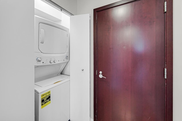 clothes washing area featuring stacked washing maching and dryer