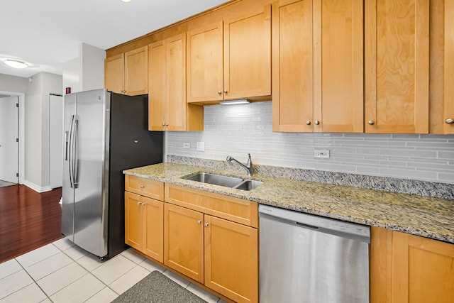 kitchen featuring light tile patterned flooring, sink, light stone counters, tasteful backsplash, and stainless steel appliances