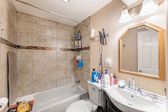 full bathroom featuring tiled shower / bath combo, vanity, and toilet