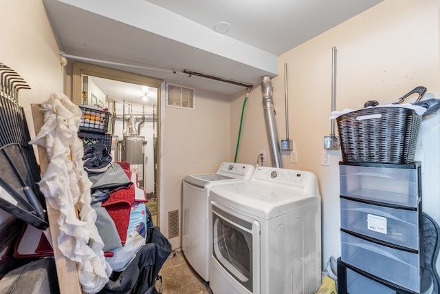 clothes washing area featuring washing machine and clothes dryer and water heater