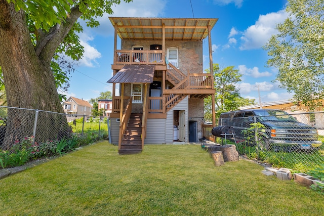 rear view of property featuring a lawn and a wooden deck