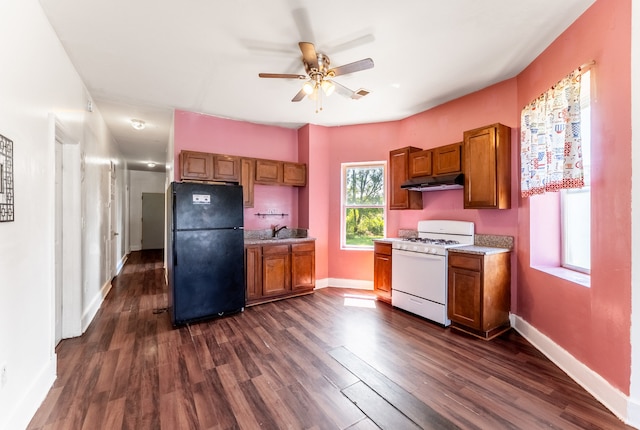 kitchen with dark hardwood / wood-style floors, white range with gas cooktop, sink, ceiling fan, and black fridge